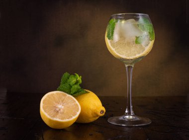 Bardakta ferahlatıcı bir yaz içeceği. Kokteyl. Bir bardakta limon ve nane. Klasik natürmort. Ön görünüm.