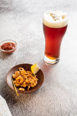 Karides ve soslu taze köpüklü bira. Mivo ve karidesler masada. Dikey çerçeve.