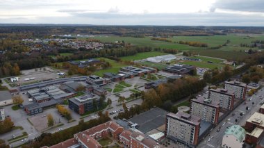 Kırsal bir kasabanın kenar mahallelerinde Sonbahar Renkli Ağaçlarla çevrili Yeşil Tarlalar