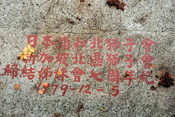 Singapore - July 9 2023: Stone with Red Chinese and Japanese Inscriptions