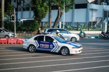 Jakarta, Indonesia - October 4 2023: White and Blue Police Car Stopped Roadside