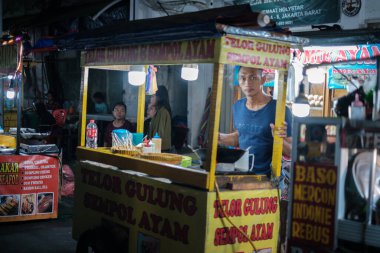 Jakarta, Indonesia - October 2 2023: Man Tending Street Food Store