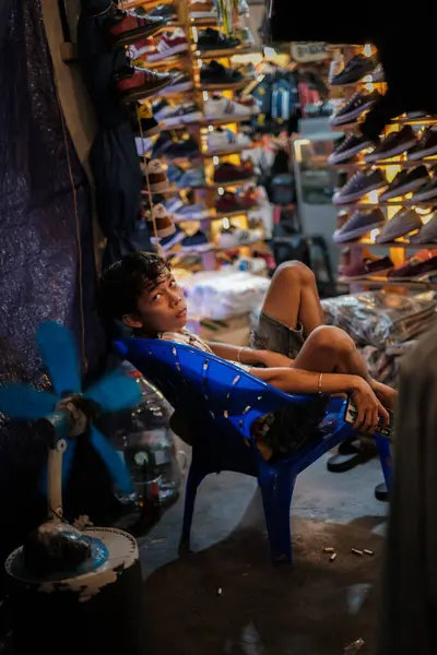 Jakarta, Indonesia - October 2 2023: Child Tending Shoe Store Night Market