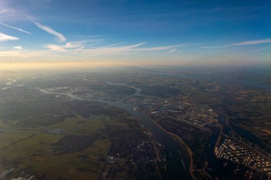 Güneşli bir günde az sayıda şehri geçen bir nehir ile Hollanda 'nın havadan görünüşü