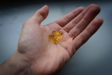 Omega 3 kapsülünü tutan insanlar. Kapatın. Yüksek çözünürlüklü ürün