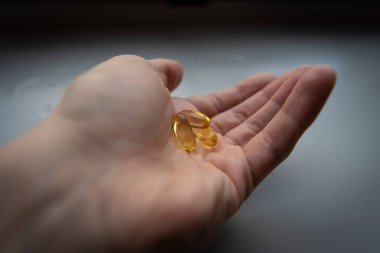 Omega 3 kapsülünü tutan insanlar. Kapatın. Yüksek çözünürlüklü ürün