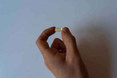 Omega 3 kapsülünü tutan insanlar. Kapatın. Yüksek çözünürlüklü ürün