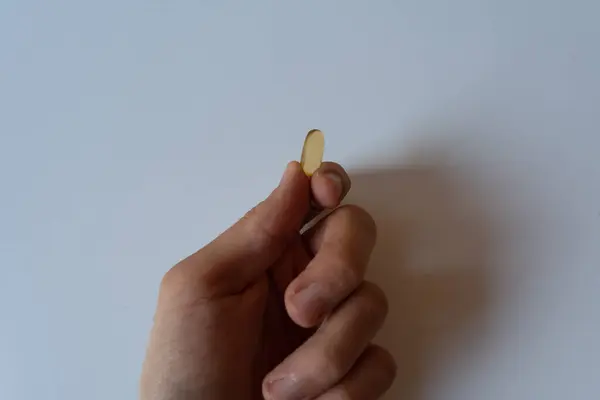 Omega 3 kapsülünü tutan insanlar. Kapatın. Yüksek çözünürlüklü ürün