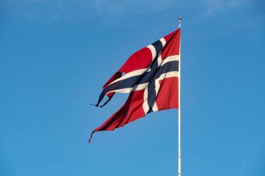 Mavi gökyüzü ve bulutlu Norveç bayrağı