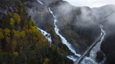Güçlü çifte şelale Lotefossen. Yaz Temmuz yağmurlu bir gün. Şelale erime ve yağmur suyuyla beslenir. Havada bir su tozu bulutu asılı duruyor. Norveç 'e git. Odda Komünü