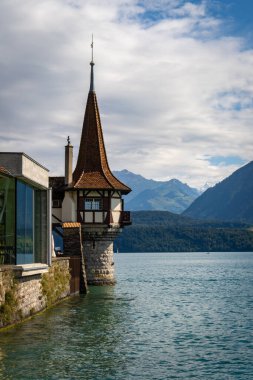 Oberhofen Castle at Lake Thunersee in swiss Alps, Switzerland. Schloss Oberhofen on the Lake Thun Thunersee in Bern Canton of Switzerland. Oberhofen castle on Lake Thun, Switzerland. clipart