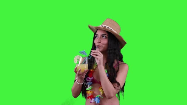 ビーチで爽やかな夏のカクテルを楽しむ若いヒスパニック女性は スタイリッシュなビキニとビーチハットを着ています 晴れた日のバイブとトロピカルリラクゼーションコンセプト グリーンスクリーン クロマキー — ストック動画