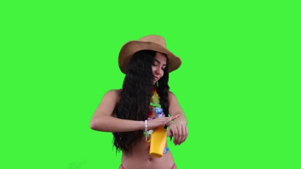 年轻的拉丁女人穿着时髦的比基尼 头戴沙滩帽 在皮肤上涂防晒霜 享受沙滩上阳光灿烂的一天 同时用防晒霜保护她的皮肤 — 图库视频影像