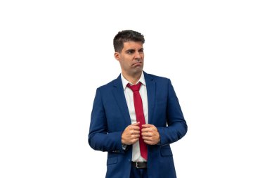 Takım elbisesini elinde tutarken bir iş adamının kafası karışmıştı. Kafa karışıklığı ve belirsizlik gösteriyordu. Kurumsal giysiler içinde şaşkın ifadesi sürpriz bir beyaz arka planı yansıtıyor.