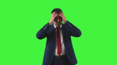 Sıkıntılı bir ifadeyle aşağıya doğru bakan işadamı, elleri ıstırap içinde başının üstüne yapışmış. İş dünyasının zorlukları arasında, stresle ve endişelerle boğuşuyor Yeşil Ekran Kroma Anahtarı