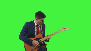 Motive olmuş iş adamı elektro gitar solosu çalarken bağırıyor. Tutku ve coşkuyla, şirket yaratıcılığını ve ifadesini somutlaştırıyor, yeşil ekran krom anahtarı.