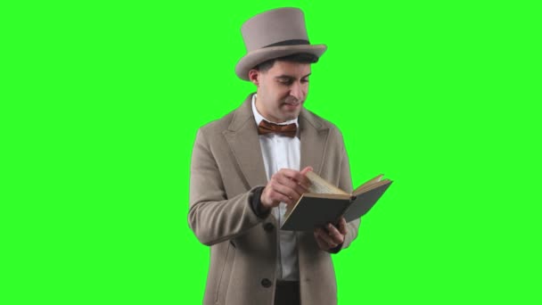 20世纪初的一位杰出绅士 头戴圆顶礼帽 身穿大衣 全神贯注地读着一本深绿色的书 — 图库视频影像