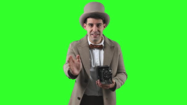 20世纪初的古旧摄影师 头戴圆顶礼帽 头戴风衣 头戴古色古香的经典相机绿色屏风 拍摄了一张正面照片 — 图库视频影像