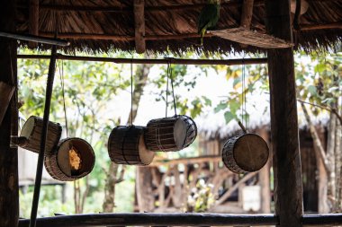 Wayuri yerli kabilesinin geleneksel şamanik davulları Ekvador 'daki Amazon yağmur ormanlarındaki bir kulübenin tavanında asılıydı. Bu görüntü Wayuri kültürel uygulamalarının özünü yansıtıyor.