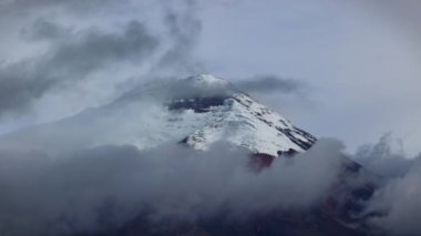 5897 metre yüksekliğindeki kar kaplı Cotopaxi Volkanı 'nın panoramik manzarası Ekvador' daki bulutlardan görkemli bir şekilde yükseliyor. Bu ikonik volkan dünyadaki en yüksek aktif volkanlardan biridir.