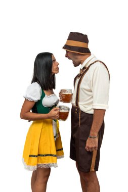 Geleneksel Oktoberfest kıyafeti giymiş, bira bardaklarını beyaz arka planda tutarken kızgın bir şekilde tartışan ve bağıran dikey genç Bavyeralı çift.