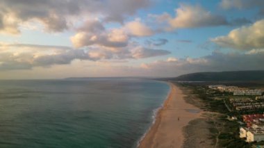 Zahara de los Atunes plajının ve arka planda ikonik Cape Trafalgar Burnu ile İspanya 'nın Cadiz kentindeki Atlanterra tatil beldesinin çarpıcı hava aracı görüntüsü