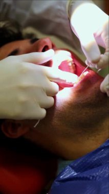 Dikey Diş Hekimi, diş sağlığı kliniğinde bir hastaya uygun diş ipi teknikleri göstererek ağız hijyeninin önemini ve sağlıklı diş ve diş etleri için etkili plaket çıkarmanın önemini vurgulamaktadır.