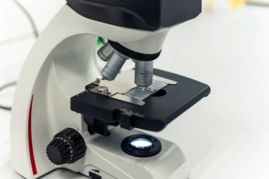 Profesyonel laboratuvar mikroskobu, modern bilim laboratuvarına yerleştirilen ve sağlık, biyoloji ve kimya alanlarındaki gelişmeler için önemli araştırmalar yürüten örnek analiz ediyor.