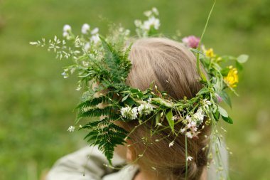 Bir çocuğun kafasında çelenk, doğayla bütünlük..