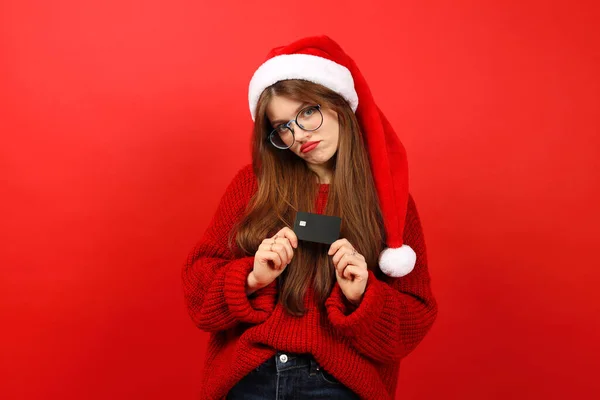 Upset Young Woman Santa Hat Holding Credit Card Red Background — Stock Photo, Image