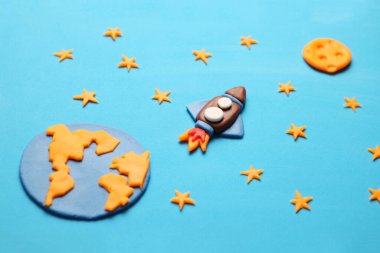 Açık alanda yaratıcı el yapımı plastik roket, astronot rüyaları. Yıldızlar, dünya ve ay gezegeni. Çizgi film sanatı.