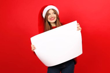 Elinde reklam posteri olan genç bir kadın, Noel arifesinde. Metin için boş boşluk.