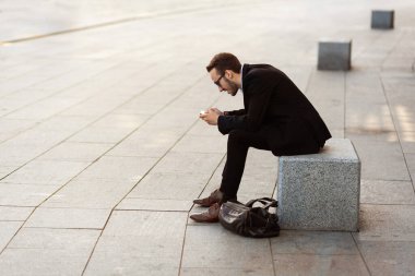 Modern young man playing on phone, browsing mobile news. Gadget Dependence.