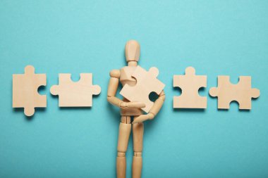 Lot of problems and depression, difficulty puzzles in hands of a wooden figure.