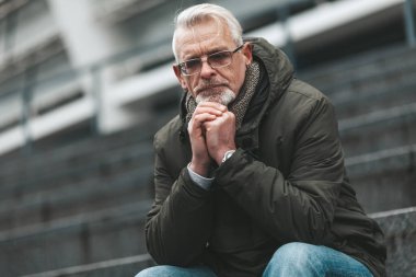 A lonely mature man sits and prays. Problems, depression and forgiveness.