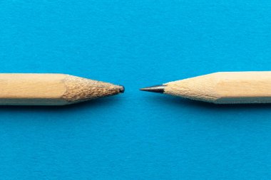 Two pencils on blue background, used and new. Experienced and inexperienced. Motivation and opportunities.