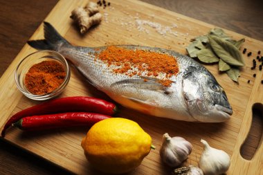 Kesme tahtasında baharatlı taze balık. Dorado..