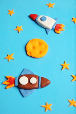 Two rocket in space, star, and moon. Plasticine art, cartoon.