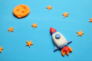 Rocket in space, star, and moon. Plasticine art, cartoon.