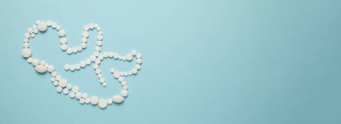 Mavi arka planda beyaz tabletlerden bir insan embriyosunun (çocuk) silueti. Yeni doğanların tedavisi, tıbbi bakım.