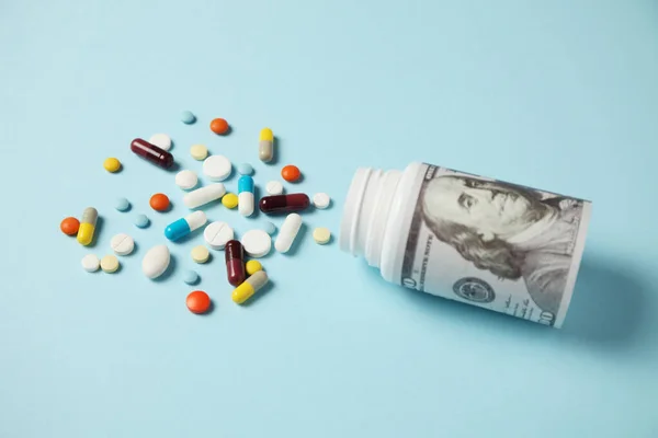 Pills and one hundred dollar bill. Dependence on drugs. Pharmaceutical industry, earnings on sick people.