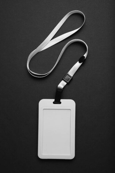 Blank badge mockup on black background. Plain empty name tag mock up hanging on neck with string.