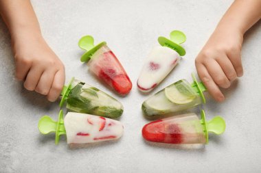 Yaz serinliği için ev yapımı tatlı, buzlu dondurma. Donmuş meyve suyu ve dondurma. Çocuk elleri.