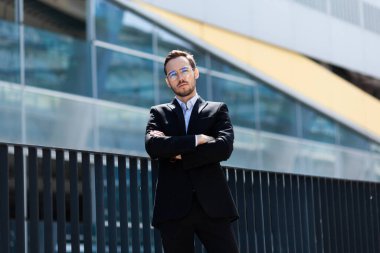 Başarılı ve kendine güvenen iş adamı kollarını göğsüne kavuşturdu..