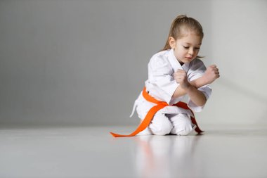 Beyaz arka planda kimonolu atletik bir çocuk, karate dersi..