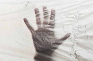 Plastik atık gezegeninin arka planında insan eli var. Plastik ambalaj ve poşet kullanımını durdurun..