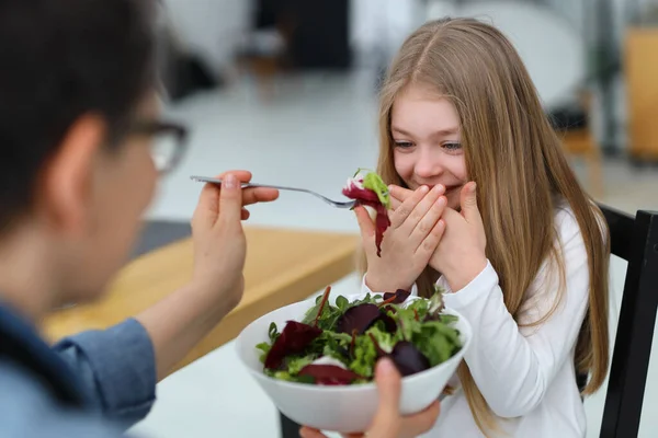 Sorrindo Menina Recusa Comer Salada Crua Mãe Alimenta Seu Filho — Fotografia de Stock