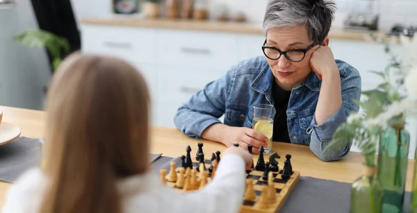 Συγκεντρωμένη Ώριμη Γιαγιά Παίζει Σκάκι Μικρό Κορίτσι Στο Σπίτι Στην — Φωτογραφία Αρχείου