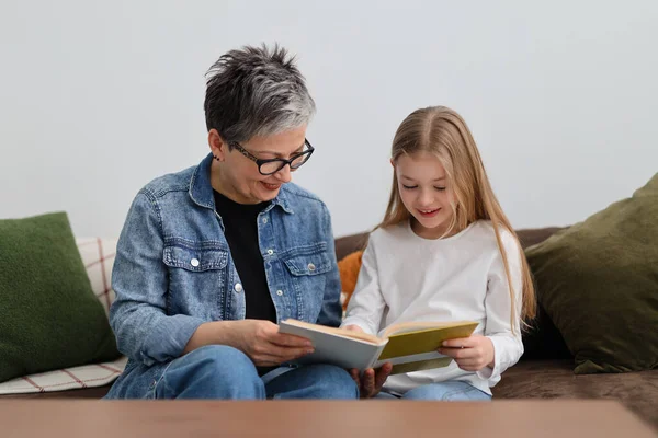 Ώριμη Γιαγιά Και Κορίτσι Διάβασαν Ένα Βιβλίο Στον Καναπέ — Φωτογραφία Αρχείου