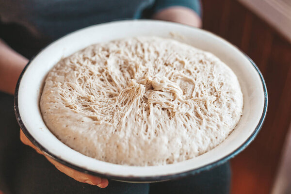 Yeast dough in a bowl. Sourdough baking recipe.